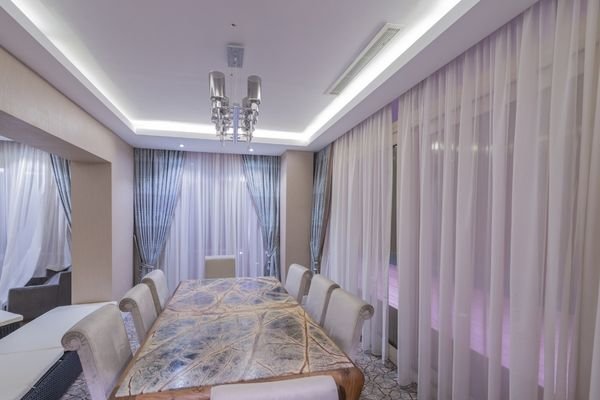 Custom upholstered bed with soft furnishings in hotel suite.